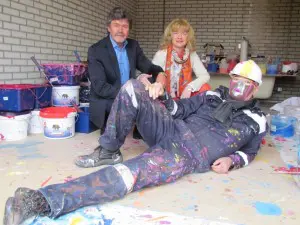 Hans en Anita ten Cate met kunstenaar Dejo op de voorgrond. Bij kunstenaarstroming toyisme staat de kunst voorop, niet de kunstenaar, vandaar het masker