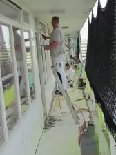 De schilders werken in twee ploegen van twee steeds aan 4½ woningen. Op de galerij aan de andere kant werken twee ploegen aan dezelfde woningen