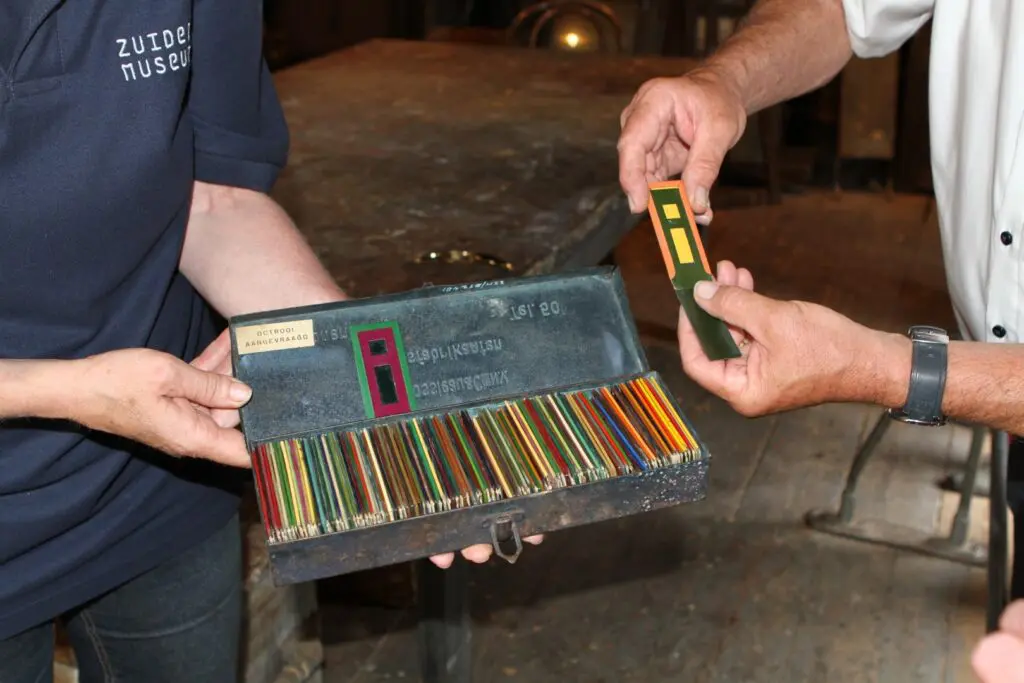 Blikken doos met kartonnen kleurstalen, in de eerste helft van de 20e eeuw uitgegeven door de voormalige verffabrikant Varossieau te Alphen aan de Rijn, om kleurcombinaties op paneeldeuren te onderzoeken (uit de collectie van het Schildersmuseum in Enkhuizen)