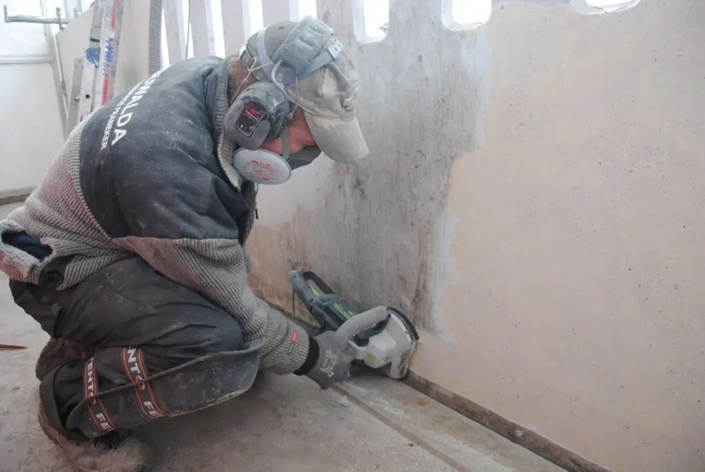 Het mechanisch reinigen van betonnen borstweringen in een project door een medewerker van een Logchies-ketenpartner