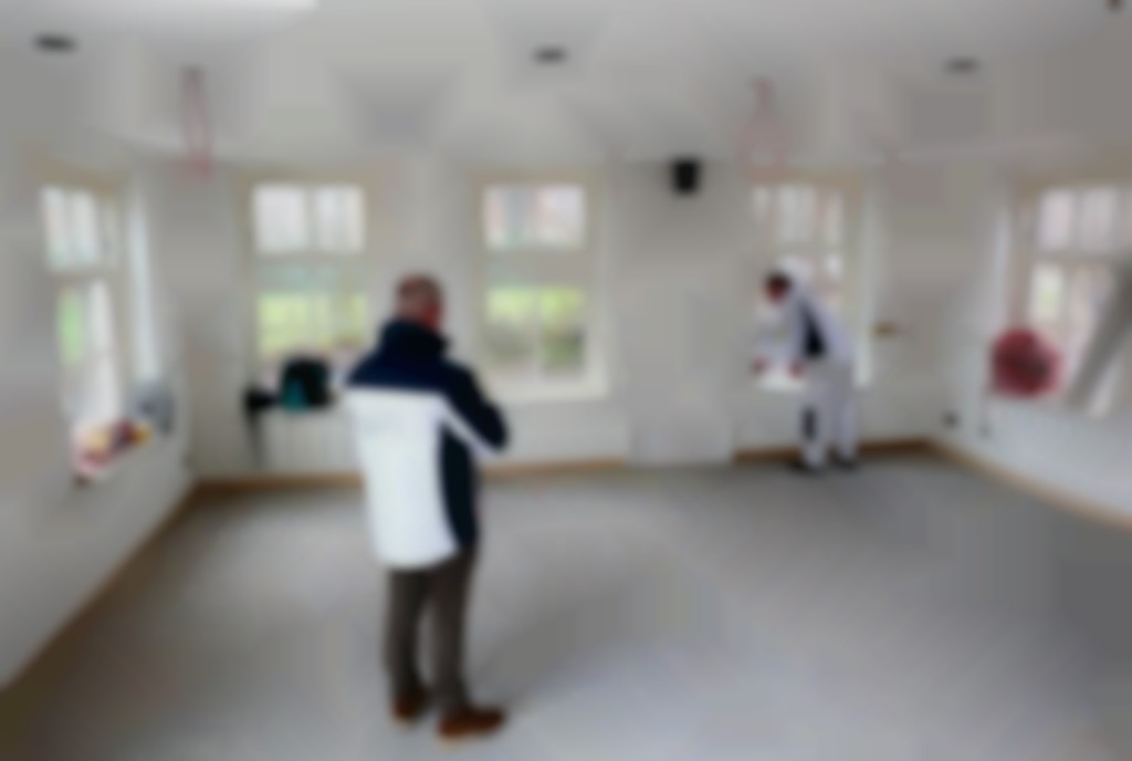 Onder het toeziend oog van Elzinga schuurt Holman de binnenkozijnen van de nieuwbouwwoning